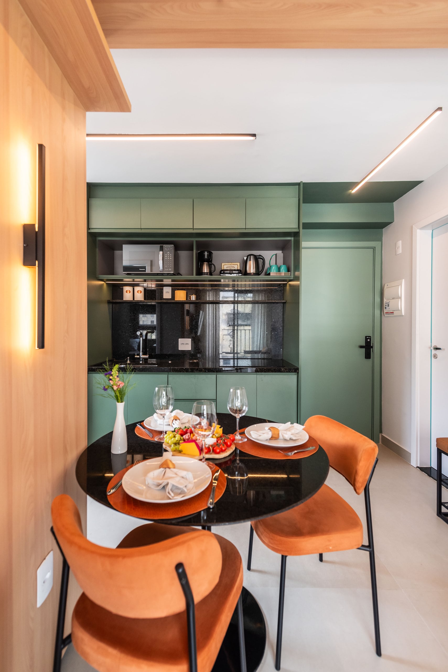 Mesa de jantar redonda entre a cozinha azul e a parede de tijolo