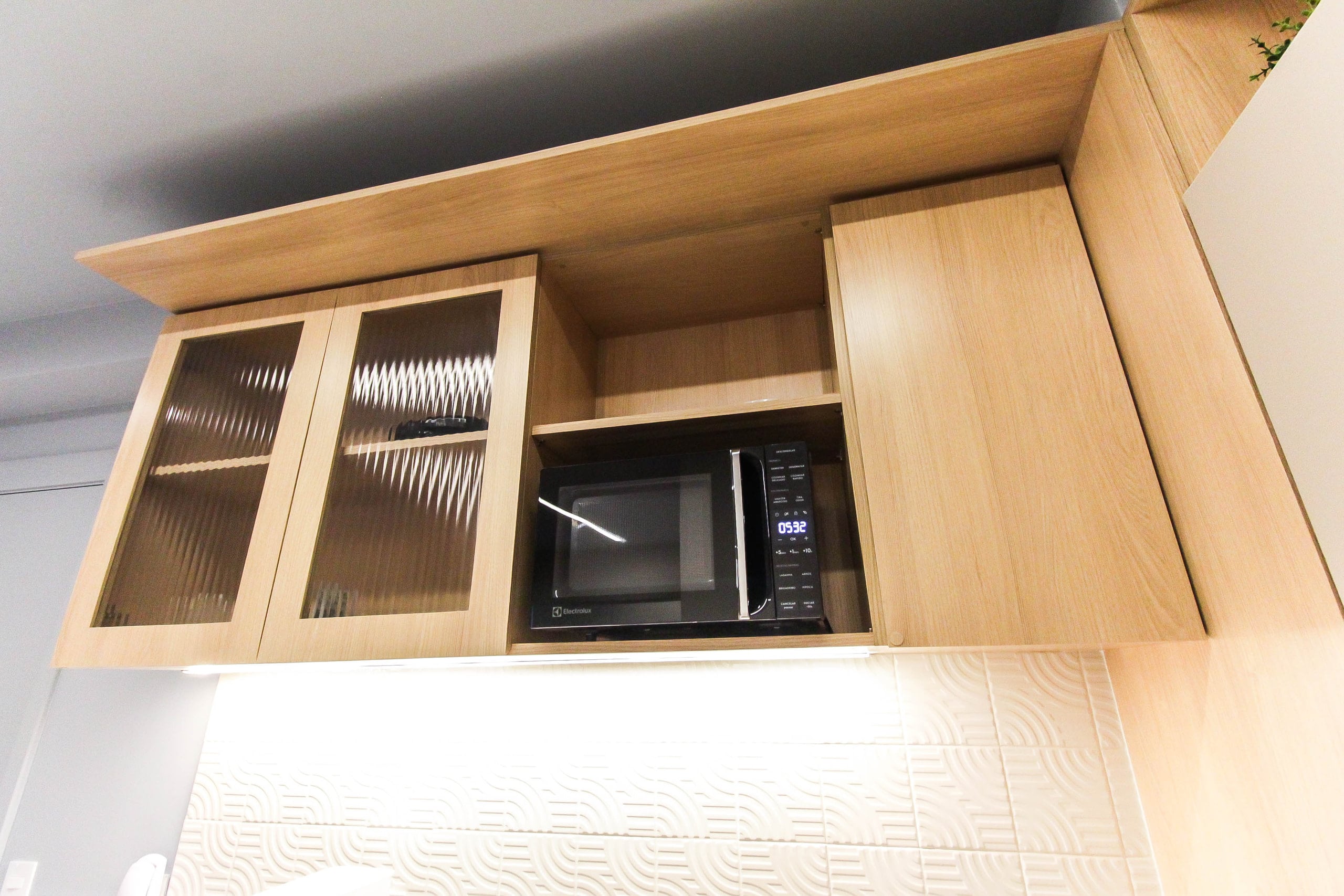 Detalhe da bancada da cozinha com cuba, cooktop e iluminação embutida