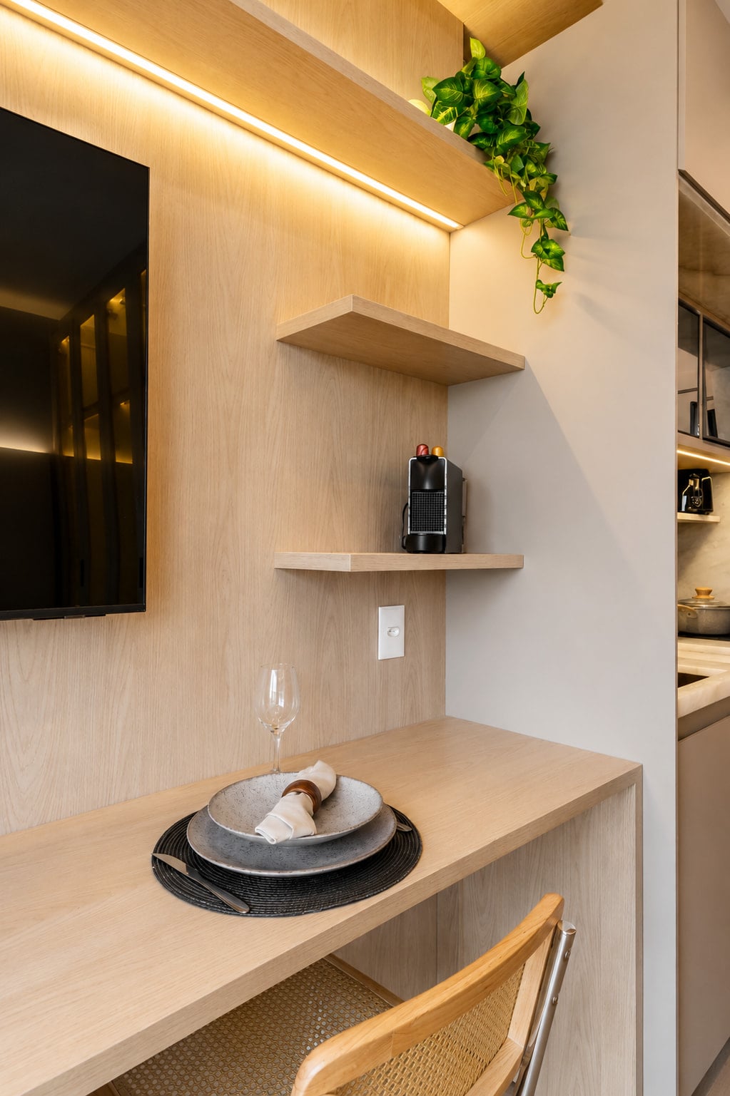 Detalhe da prateleira em madeira com louça e cafeteira